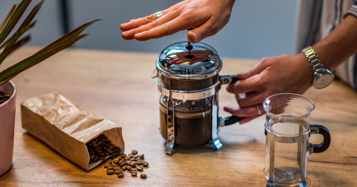 Person pushing down a French Press