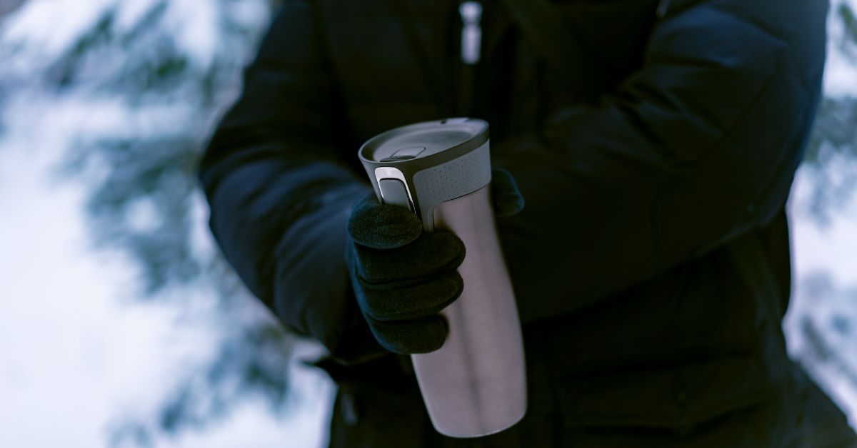 Person holding a thermos in colf weather
