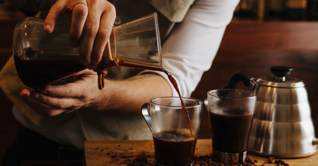 Decaf Coffee Feature Image- Man pouring Decaf coffee from a fliter into a coffee cup
