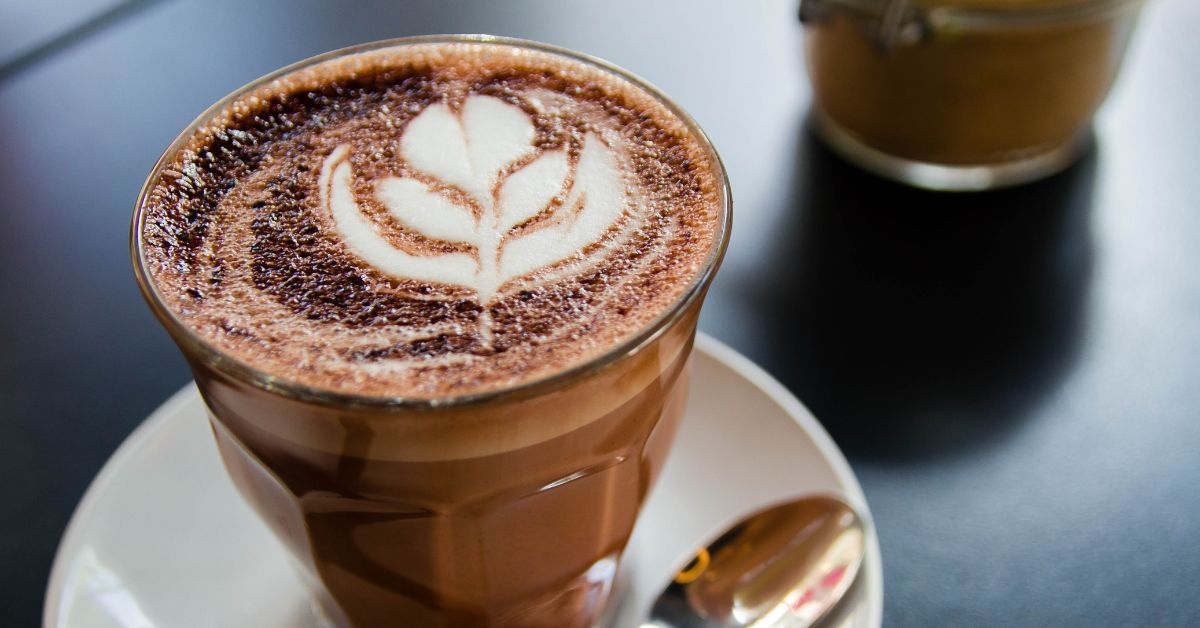 A glass of hot chocolate with some barista art on top