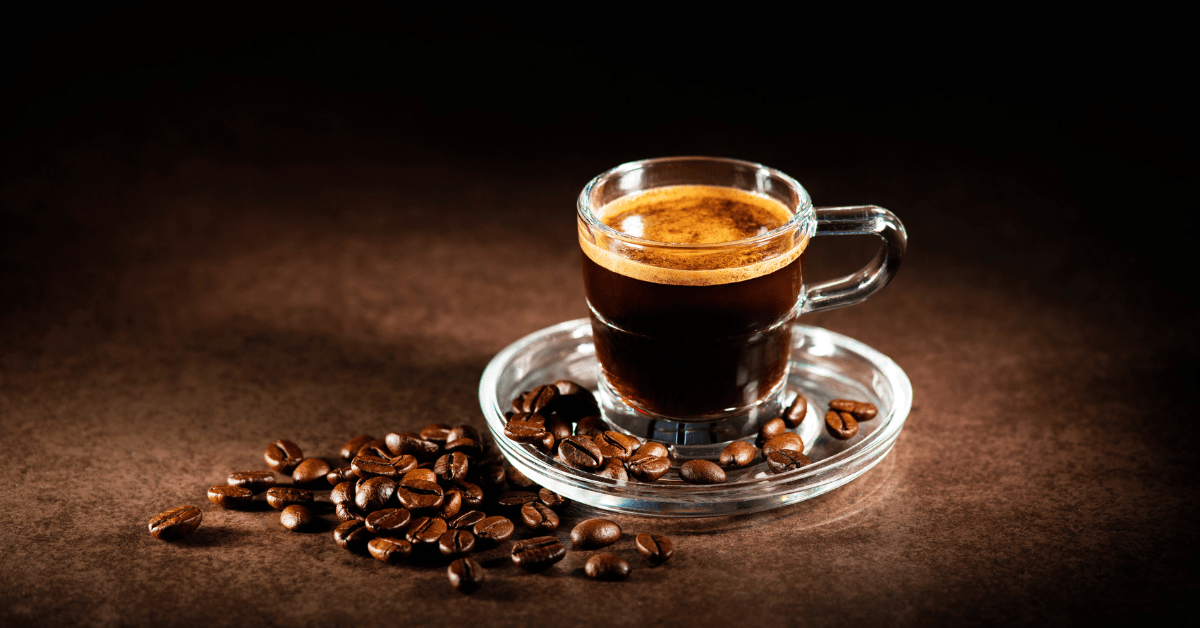 Close up of an espresso with some beans laying next to it